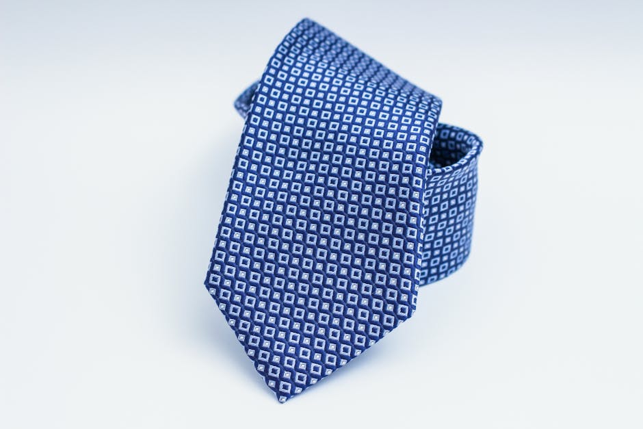 Close-up of a blue patterned necktie on a white background, perfect for fashion and business themes.